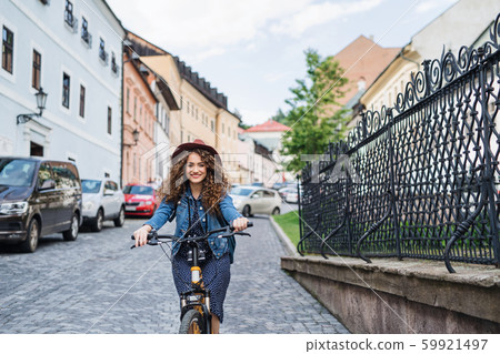 Beautiful young woman tourist traveller with electric scooter in small town. Beautiful young woman tourist traveller with electric scooter in small town. 59921497