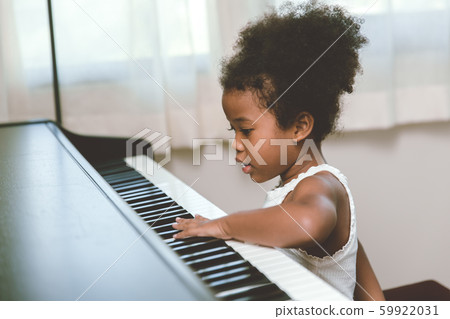 little child girl touching looking at the piano interested impression with music instrument. little child girl touching looking at the piano interested impression with music instrument. 59922031