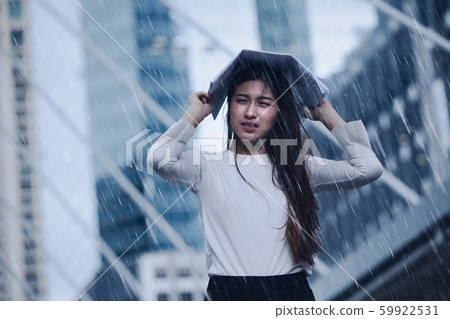 Girl in the heavy rain storm cover head with newspaper for economic obstacle passing 59922531