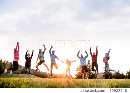 Large group of fit and active people jumping after doing exercise in nature. Large group of fit and active people jumping after doing exercise in nature. 59922548