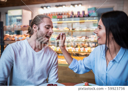 Bearded husband tasting dessert while spending morning with wife Bearded husband tasting dessert while spending morning with wife 59923736