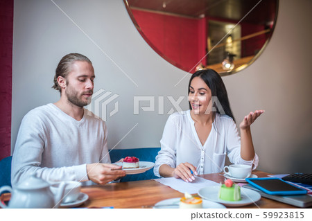 Wife speaking about dessert while making menu with husband 59923815