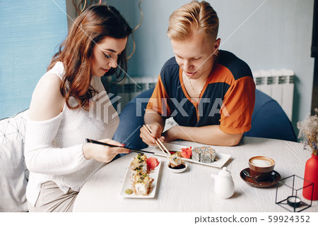 Couple sitting in a caffe and eating sushi 59924352