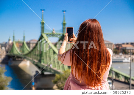 Young red-haired girl in a pink dress makes a Young red-haired girl in a pink dress makes a 59925273