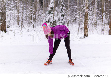 young woman warming up before jogging in a winter 59925455