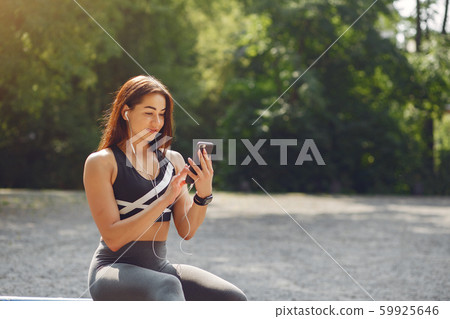 Sports girl training with phone and headphones 59925646