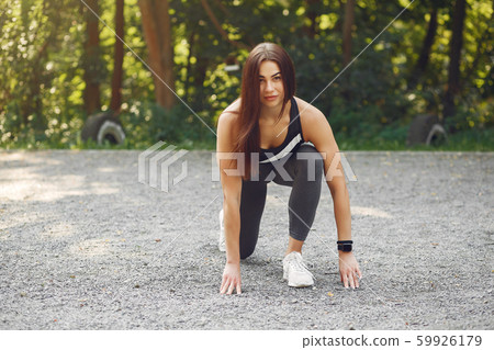 Sports girl in a black top training in a summer park Sports girl in a black top training in a summer park 59926179