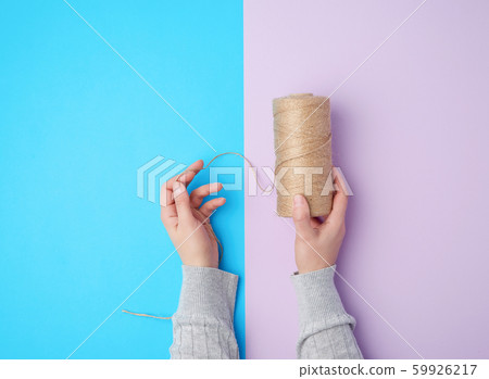 female hands holding a skein with brown eco thread female hands holding a skein with brown eco thread 59926217