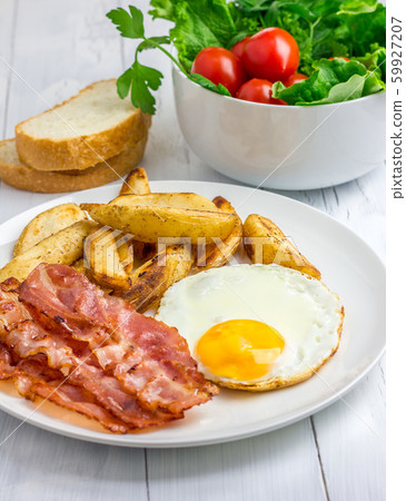 Hearty breakfast with bacon, fried egg, potato Hearty breakfast with bacon, fried egg, potato 59927207