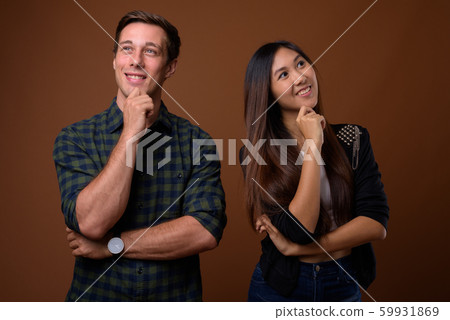 Happy young couple thinking and looking up 59931869