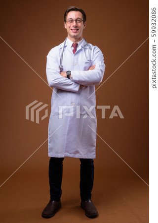 Young handsome man doctor against brown background 59932086