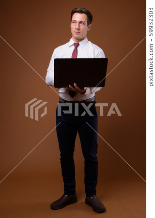 Young handsome businessman against brown background 59932303