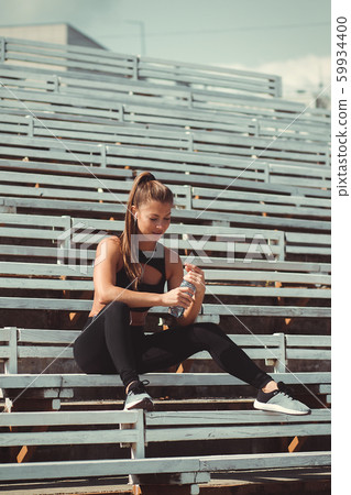 Tired woman in headphones resting and drinking 59934400