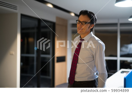 Portrait Of Mature Businessman In Office At Night Portrait Of Mature Businessman In Office At Night 59934899
