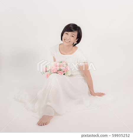 A woman who sits on the white floor and brings out happiness 59935252