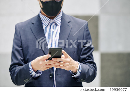 Businessman texting coworker 59936077