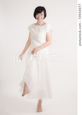Middle-aged woman in white skirt standing barefoot dancing dance valley 59938977