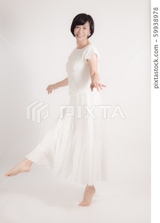 Middle-aged woman in white skirt standing barefoot dancing dance valley 59938978