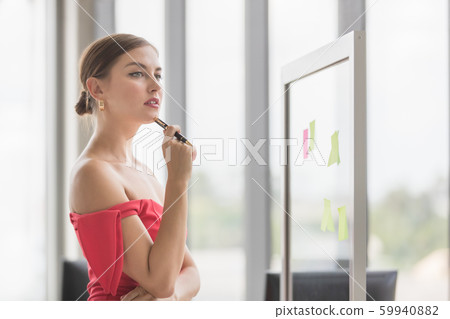 Businesswoman recording idea on sticky notes.. 59940882