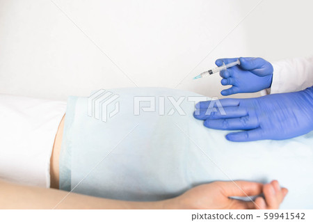 Doctor proctologist treats a patient for hemorrhoids with the help of modern method sclerotherapy, white background, treatment haemorrhoids, copy space 59941542