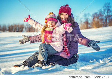 Active mother and daughter playing in winter park 59942527