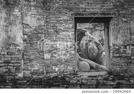 Ayutthaya ancient ruined Buddha statue seen through window on ruined wall 59942664