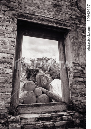 Ayutthaya ancient ruined Buddha statue seen through window on ruined wall 59942667