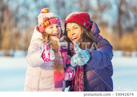 Positive mother and daughter playing in winter park Positive mother and daughter playing in winter park 59942674