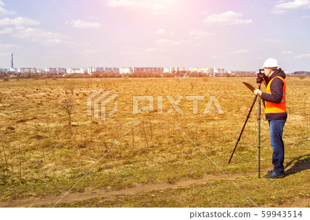 Surveyor worker measures the distance and length using measuring equipment for the construction of a new micro district, copy space, Angle measurement Surveyor worker measures the distance and length using measuring equipment for the construction of a new micro district, copy space, Angle measurement 59943514