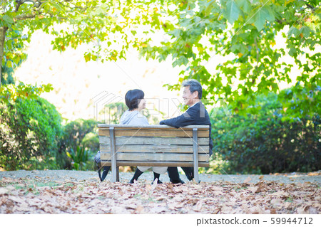 Back view senior couple snuggling on bench autumn happy family couple travel Back view senior couple snuggling on bench autumn happy family couple travel 59944712