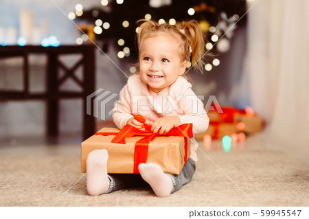 Happy baby girl enjoying Christmas gift at home 59945547