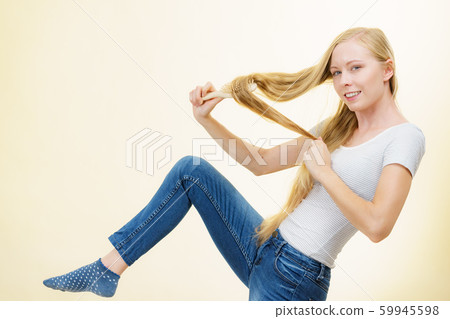 Blonde girl brushing her long hair Blonde girl brushing her long hair 59945598