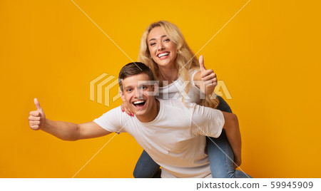 Cheerful millennial couple showing thumbs up, having fun together 59945909