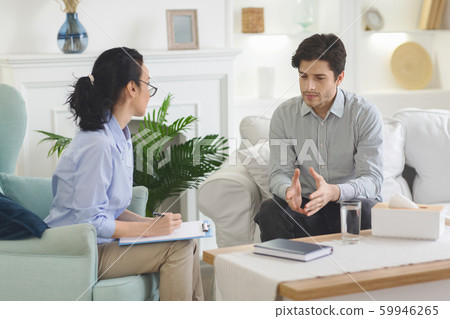 Young man emotionally speaking at psychotherapist session 59946265