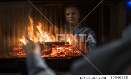 A man with a glass of spirits sits by the fireplace A man with a glass of spirits sits by the fireplace 59946588