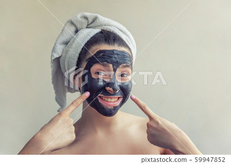 Woman applying black nourishing mask on face Woman applying black nourishing mask on face 59947852