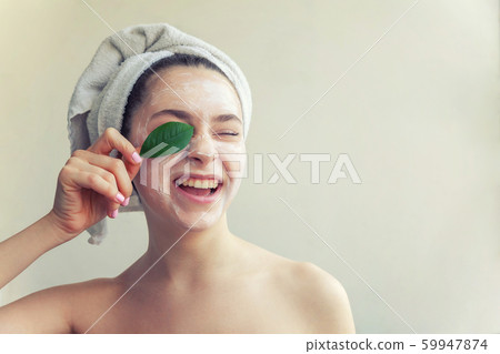 Woman face with green leaf and cream or nourishing 59947874