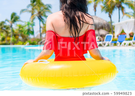Beautiful young woman relaxing in swimming pool. Beautiful young woman relaxing in swimming pool. 59949823
