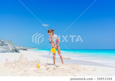 Adorable little girl playing with beach toys during tropical vacation 59951504