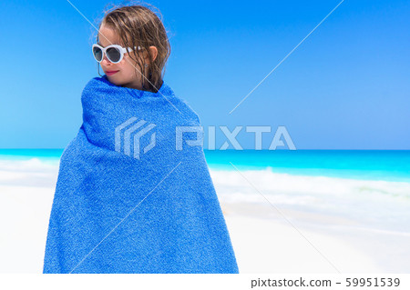 Adorable little girl wrapped in towel at tropical beach after swimming in the sea Adorable little girl wrapped in towel at tropical beach after swimming in the sea 59951539