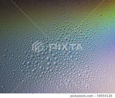 Water drops on glass with colorful rainbow background. Morning dew on the window with a refractive reflection of multicolored sunlight. Water drops on glass with colorful rainbow background. Morning dew on the window with a refractive reflection of multicolored sunlight. 59954126