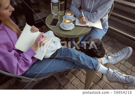 Concentrated girl keeping her notebook on knees Concentrated girl keeping her notebook on knees 59954218