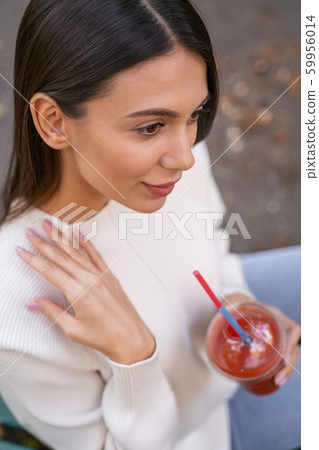 Close up of cheerful woman that holding glass with smoothie 59956014