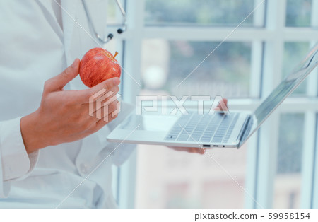 Doctors or nutritionists hold apples and laptops Doctors or nutritionists hold apples and laptops 59958154