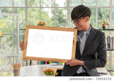 Happy Asian young businessman holding an empty Happy Asian young businessman holding an empty 59958159