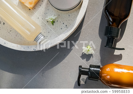 Creams, shampoo and other hair and body care on the grey stone background with natural sunlight Creams, shampoo and other hair and body care on the grey stone background with natural sunlight 59958833