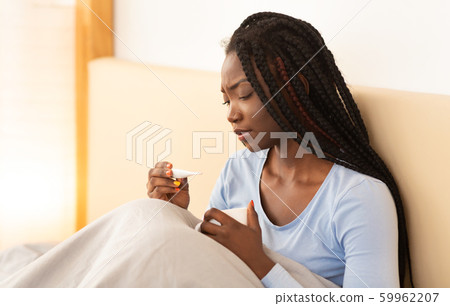African American Girl Having Fever Holding Thermometer Sitting In Bed African American Girl Having Fever Holding Thermometer Sitting In Bed 59962207