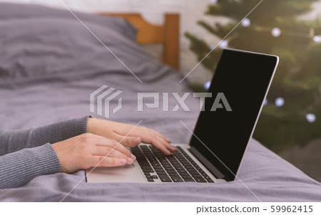 Female hands typing on laptop with blank screen Female hands typing on laptop with blank screen 59962415