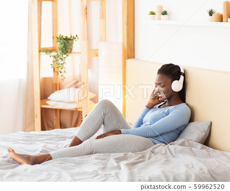 African American Girl In Headphones Listening To Song At Home African American Girl In Headphones Listening To Song At Home 59962520