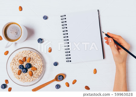 Female hand writing in blank notebook 59963028